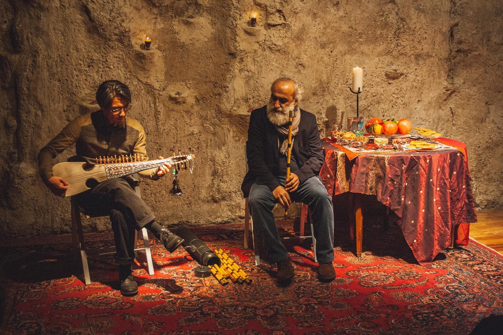 Nuit de Yalda : Kengo Saito au rubab et Masoud Jahed au ney, à côté de la table de Yalda aux grenades