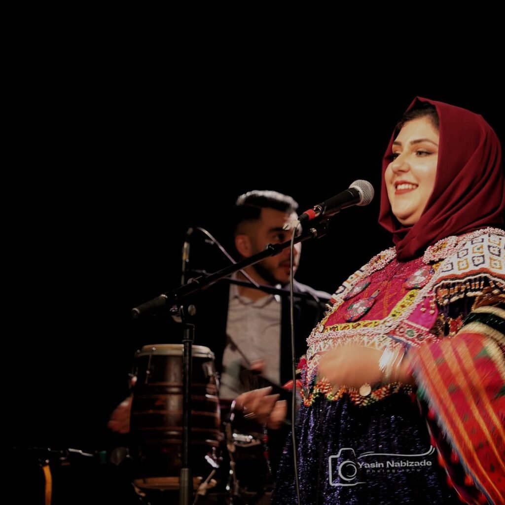 Chanteuse en costume traditionnel afghan sur scène lors de la fête de Nawroz